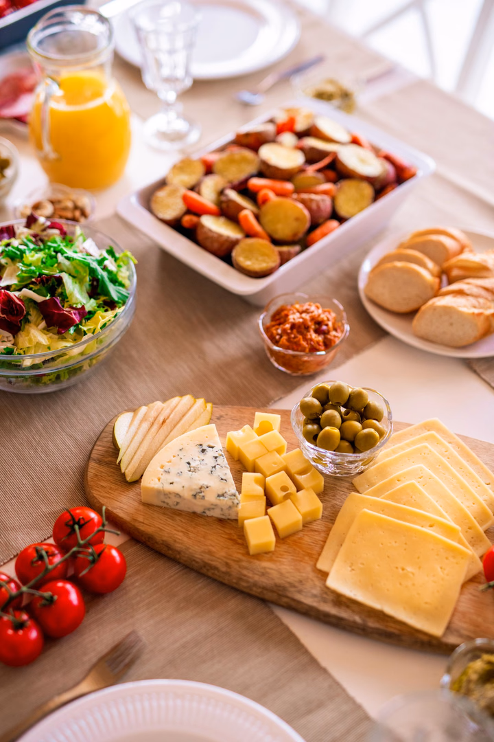 Brot, Käse und Salate stehen auf einer Tafel.