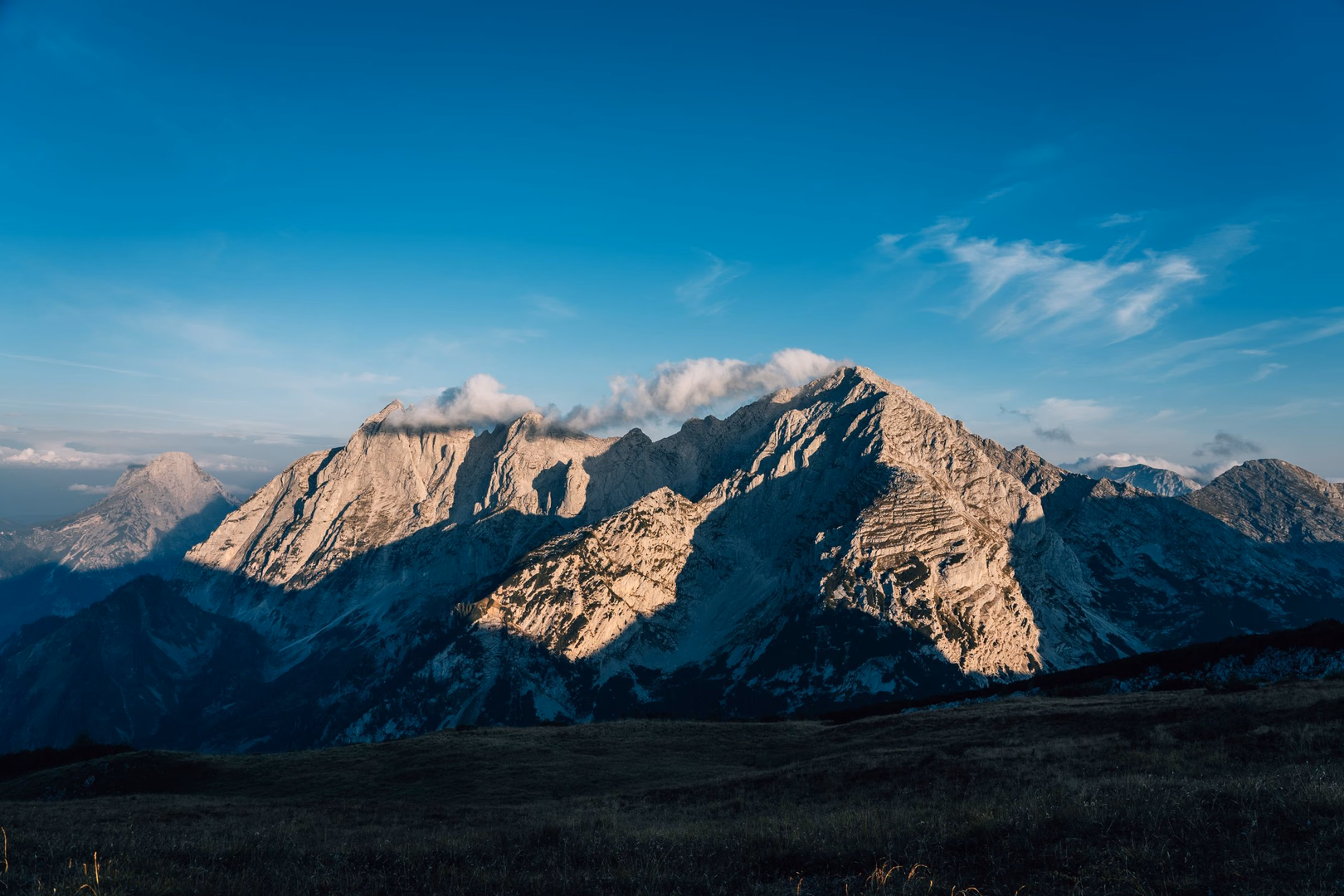 Morgenlicht fällt auf eine Berglandschaft.