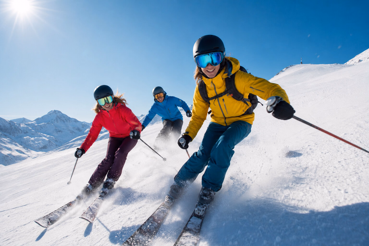 Drei Studierende carven bei strahlendem Sonnenschein über die Piste